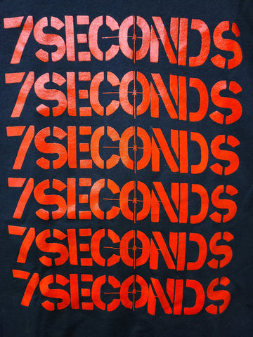 7 Seconds logo red print  stacked vertically 6 times on black tee 